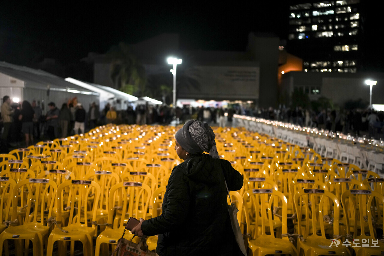 29일(현지시각) 이스라엘 텔아비브 미술관의 '인질 광장'으로 알려진 곳에서 한 여성이 하마스에 억류된 인질들을 묘사한, 묶여 있는 빈 의자 설치물들을 바라보고 있다. 카타르, 이스라엘, 미국, 이집트 대표단이 휴전 연장 논의를 이어가는 중에 하마스 측은 아직 휴전 추가 연장에 합의된 것이 없다고 전했다. (사진=뉴시스)